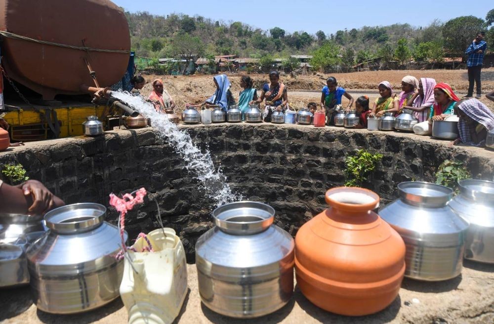Thane : Villagers gather around a dry well to collect water provided by tankers in Shahapur Taluka, Thane District, Maharashtra on Sunday, May 14, 2023. (Photo:IANS)