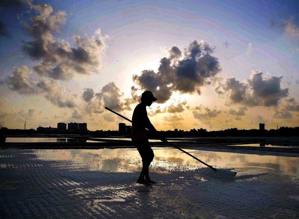 Mumbai: A silhouette of a worker extracting salt from the salt pan against the pre  Monsoon Clouds, in Mumbai, on Friday, May 26, 2023. (Photo: Nitin Lawate/IANS)