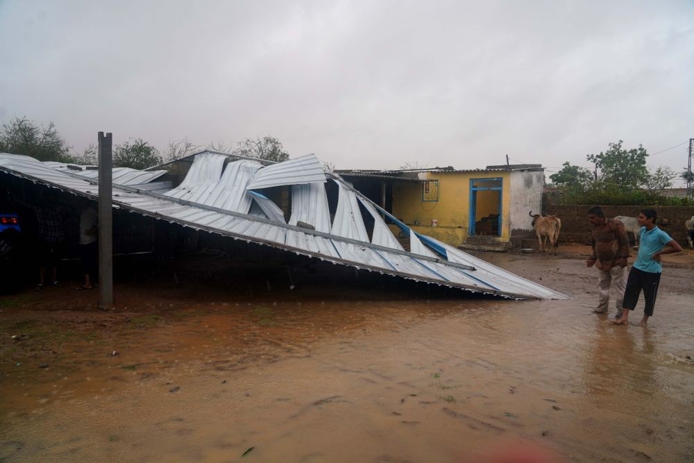 Kutch : A boy walks near a collapsed wall of a house at moti-bhadai village in Mandvi, Kutch, on Friday, June 16, 2023. (Photo: IANS/Siddharaj Solanki)