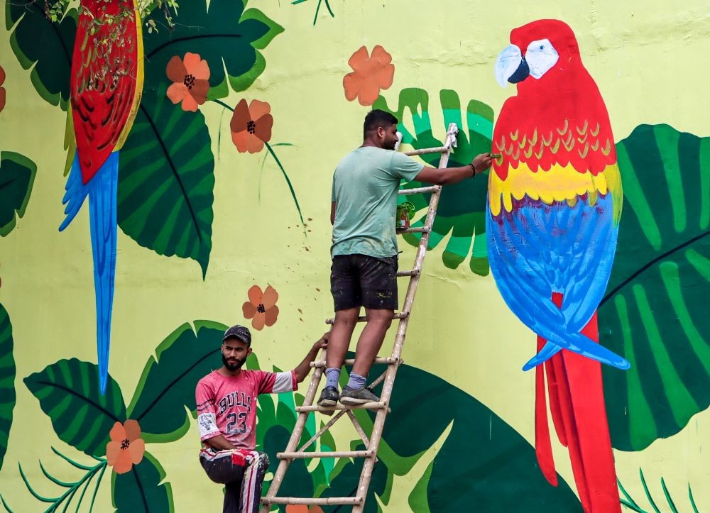 New Delhi: An artist is seen giving final touches to painted graffiti on a wall at Lodhi Colony in New Delhi on Friday, June 30, 2023. (Photo: IANS/Wasim Sarvar)