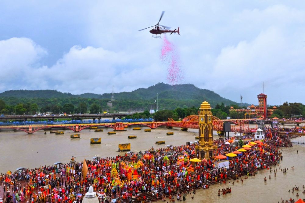 Haridwar : A helicopter showers rose petals on the devotees at Har Ki Pauri in Haridwar on Thursday, July 06, 2023. (Photo: IANS/Rameshwar Gaur)