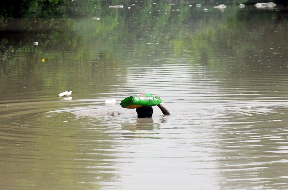New Delhi: A man wades through a waterlogged road near Red fort following the rise in the water levels of the Yamuna river, in New Delhi, in Friday, July 14, 2023. (Photo: IANS/Qamar Sibtain)