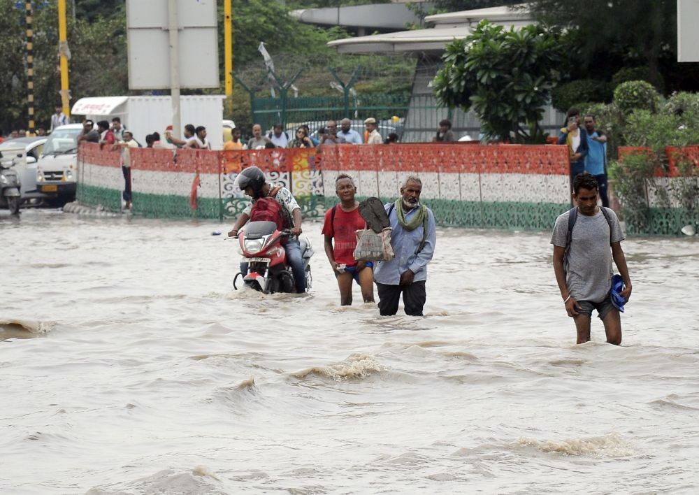 New Delhi: Commuters wade through a flood-affected area near ISBT following monsoon rains, in New Delhi, on Thursday, July 13, 2023. The water level of the Yamuna river in Delhi was recorded 208.46 metres on Thursday morning. (Photo: IANS/Qamar Sibtain)