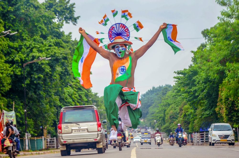 Bhubaneswar: An artist of "Bande Mataram" paints himself in the colors of the Indian national flag and performs during a street play on the eve of the 77th Independence Day in Bhubaneswar on Monday, August 14, 2023. (Photo: IANS/Biswanath Swain)