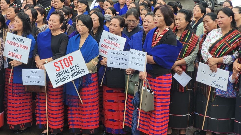 Naga women in traditional attires carrying placards during the solidarity prayer for violence against women and unrest in Manipur organized by eight apex tribal women organization at PHQ Junction Kohima on August 12. (Morung Photo)