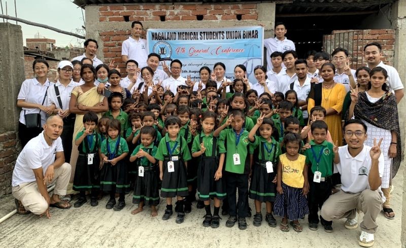 Officials with pupils of Aixin Educational Centre.