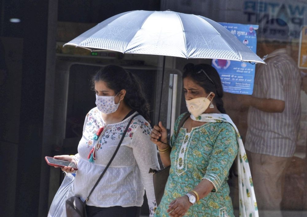 New Delhi : Women using umbrella to protect themself from scorching heatwave, New Delhi on Saturday, April 23, 2022 (Photo: Wasim Sarvar/IANS)