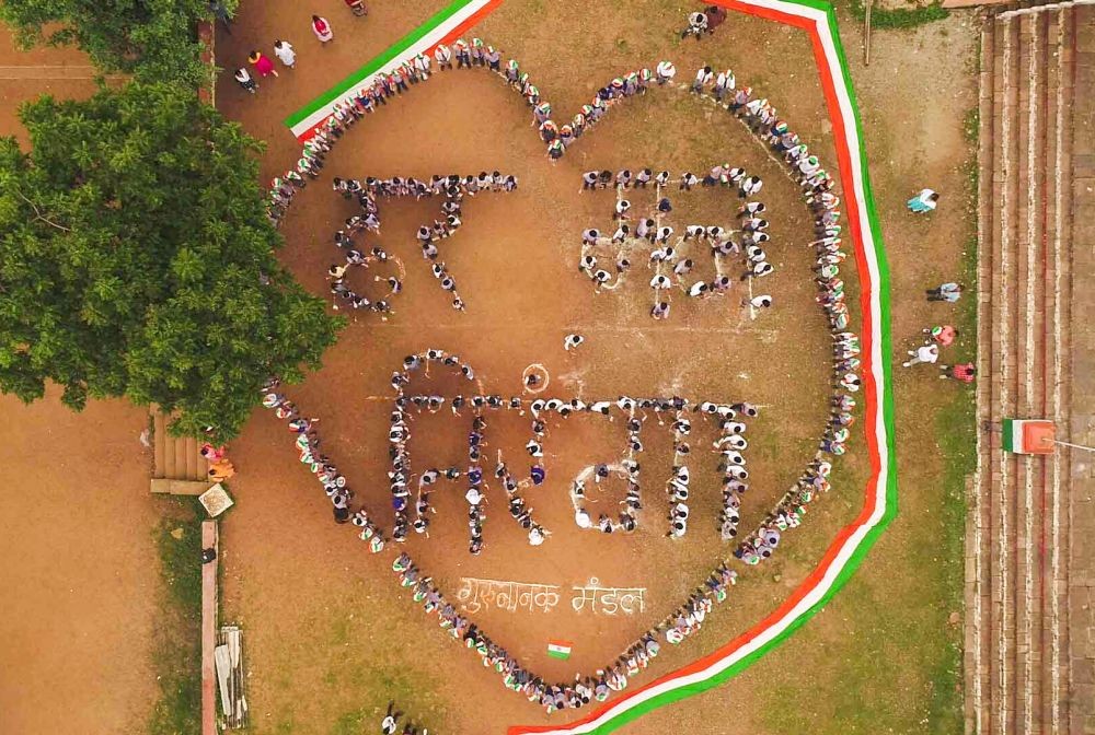 Bhopal: People stand in a way that reads 'Har Man Tiranga' ahead of Independence Day at Idgah Hills Guru Nanak Mandal in Bhopal on Tuesday, August 08, 2023. (Photo: IANS)