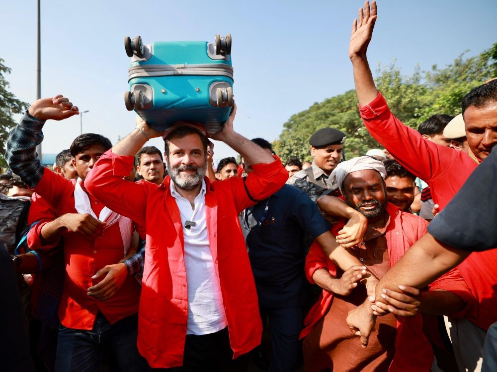 New Delhi: Congress leader Rahul Gandhi, wearing the porters' trademark red shirt and badge, carries a luggage over his head during an interaction with porters at Anand Vihar railway station, in New Delhi, Thursday, Sept. 21, 2023. (IANS/Twitter:@INCIndia)