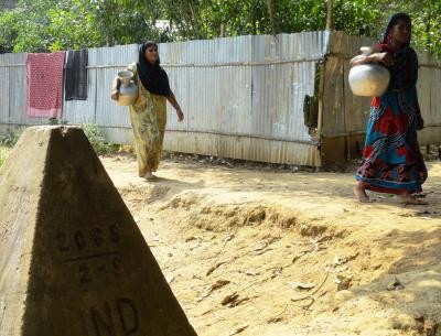 Indian women living in Adampur village situated outside the Indo-Bangladesh border fencing return back after fetching water from Ghilatali village in Comilla of Bangladesh; in Tripura on May 19, 2014. (IANS File Photo)