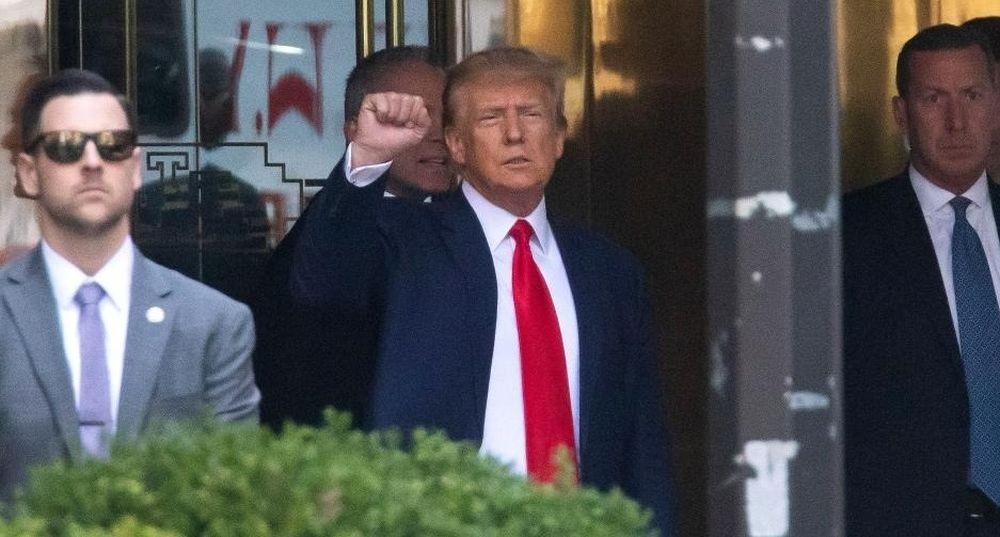 Former U.S. President Donald Trump (C) raises his fist as he leaves Trump Tower for his arraignment at the Manhattan Criminal Court in New York, the United States, on April 4, 2023. (IANS Photo)
