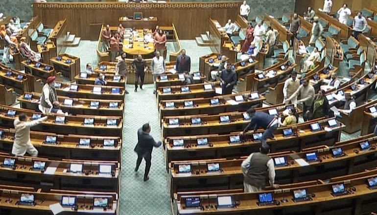 New Delhi: An unidentified man jumps in the Lok Sabha chamber from the visitor's gallery following which the House was adjourned, in New Delhi, Wednesday, December 13, 2023. (Photo: IANS/Sansad TV)
