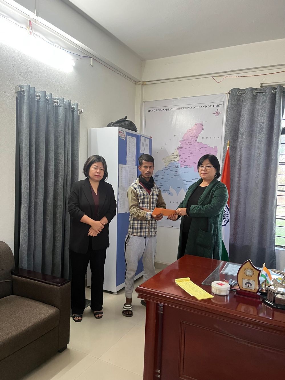 Deputy Commissioner & Chairman DDMA Niuland, Sara S. Jamir handing over immediate relief to Abdul Noor whose house was razed down by fire at Niuland Town on January 3, 2024 in the presence of S Athsangla, ADC & CEO, DDMA Niuland.
