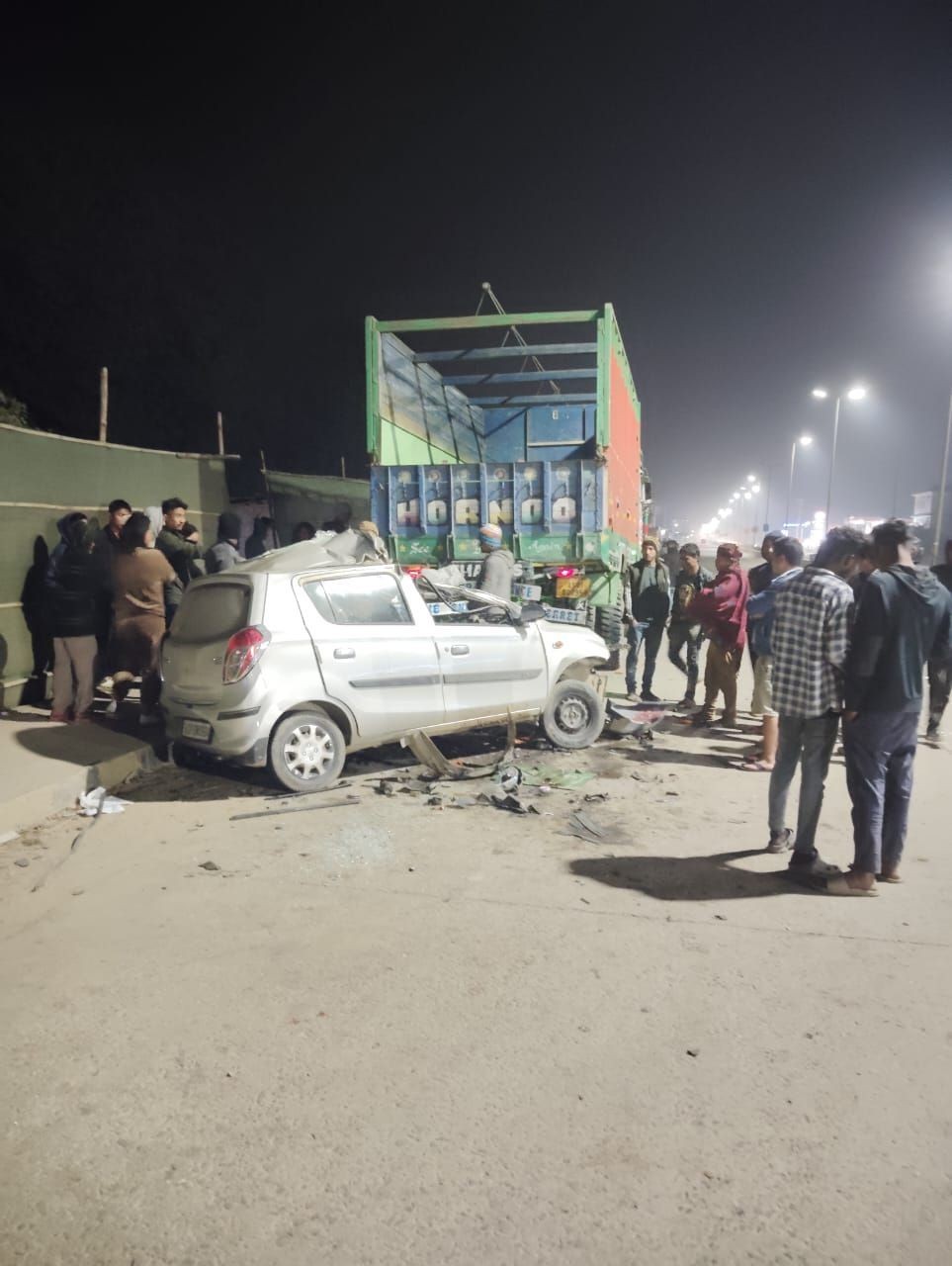Onlookers gather at the scene of the vehicle collision that claimed two lives on the night of January 20. According to the Dimapur Police, the accident occurred when the vehicle rammed into stationary the truck near the 7th Mile petrol pump, Chümoukedima, along National Highway-29.
