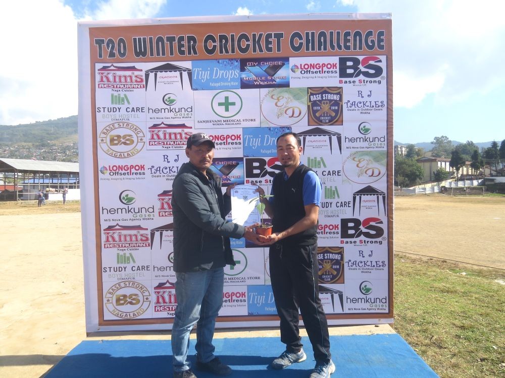 Wokha District Cricket Association President Chenithung T Lotha, the patron of the day honouring the man of the match Abemo Kikon.