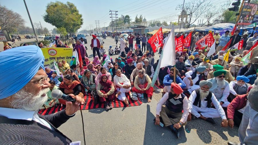 Farmers sit on a road during a protest over their various demands in Mohali on Friday, Feb. 16, 2024. (Photo: IANS/Ajay Jalandhari)