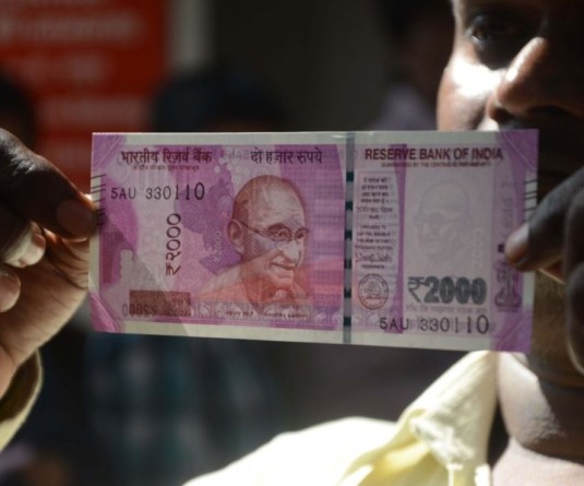 A man shows the new Rs 2000 currency note in Mumbai on Nov. 10, 2016. (Photo: IANS)