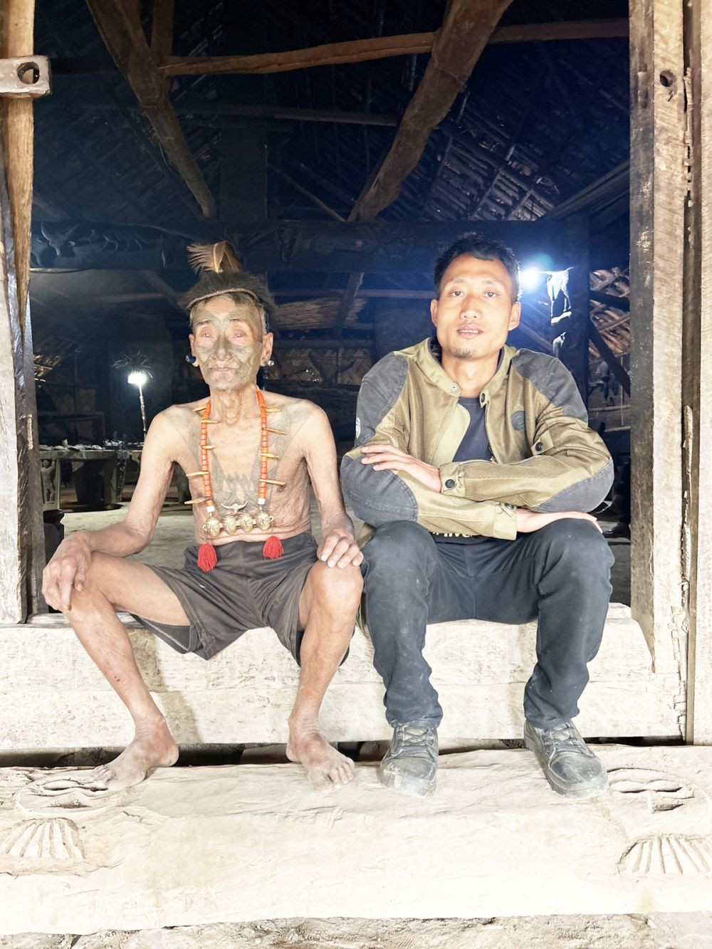 Nokao Konyak is seen here sitting with his grandfather in their kitchen doorway at Longwa village, Mon District. (Morung Photo)