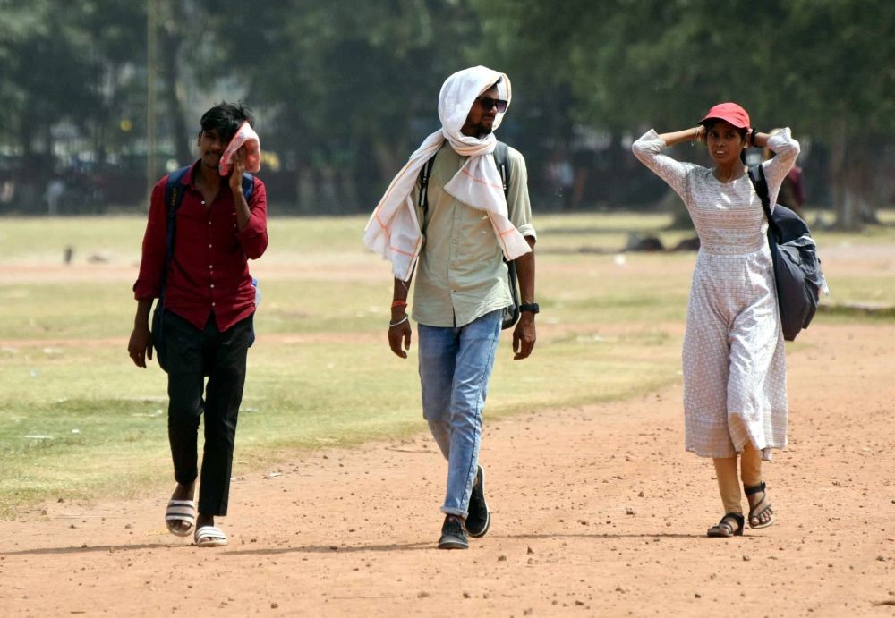 Patna: People use a piece of cloth and a cap to protect themselves from the scorching heat on a hot summer day in Patna on Tuesday, June 13, 2023. (Photo: IANS)
