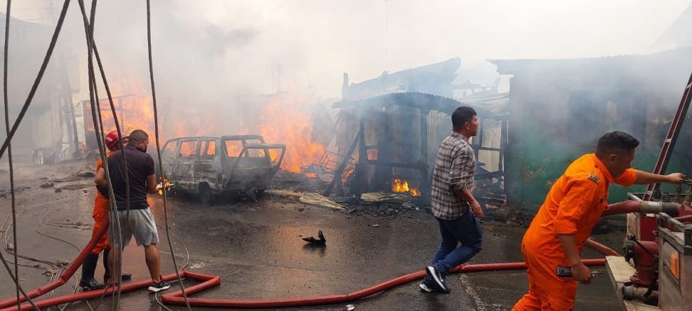 Fire tenders trying to douse the fire which broke out at Kitsubozou near Chakhesang Baptist Church, Kohima on Tuesday. Around 12 shops were gutted by the blaze. (Morung Photo)