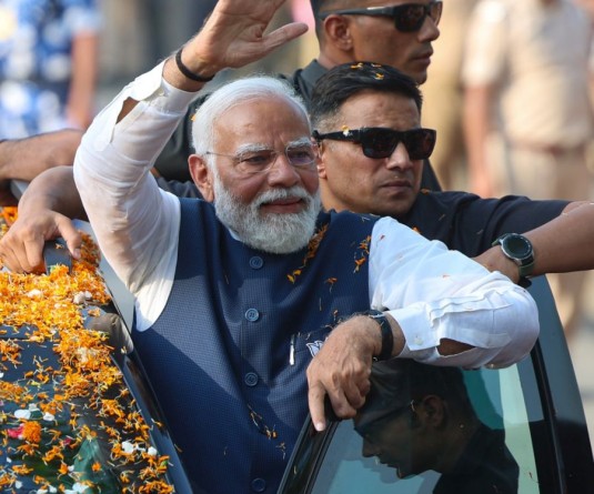 Prime Minister Narendra Modi during a roadshow ahead of Lok Sabha Elections, in Raiganj,Tuesday, April 16, 2024.(IANS)