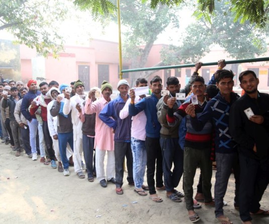 Voters wait in queue to cast their vote for the Rajasthan Assembly election, in Bharatpur district, Saturday, November 25, 2023. (Photo: IANS/Yuvnish)