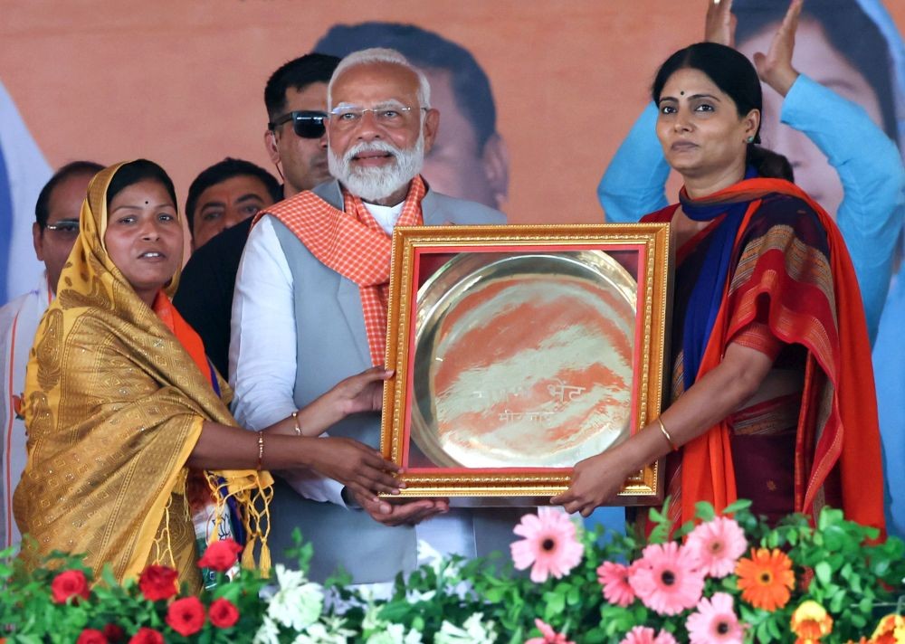 Mirzapur: Prime Minister Narendra Modi being presented a memento by candidate Anupriya Patel from Mirzapur Lok Sabha seat during a public meeting ahead of Lok Sabha elections, in Mirzapur, Sunday, May 26, 2024.(Photo: IANS)