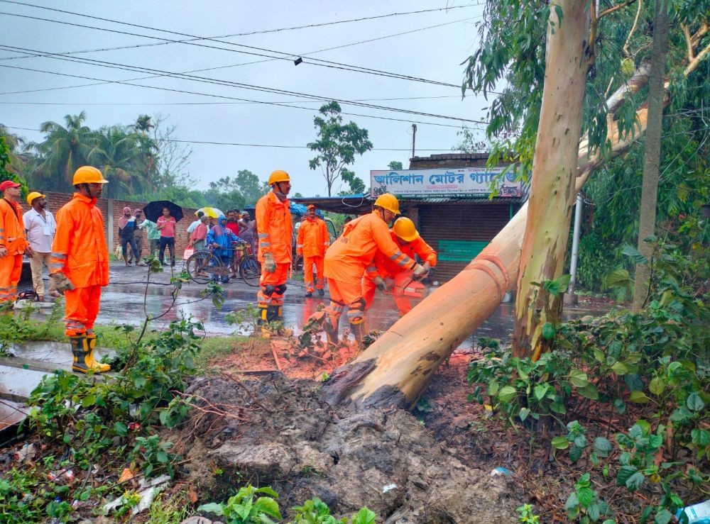 North 24 Parganas: NDRF personnel remove an uprooted tree from a road after the landfall of Cyclone 'Remal', in North 24 Parganas district, Monday, May 27, 2024.(IANS/X/@NDRFHQ)