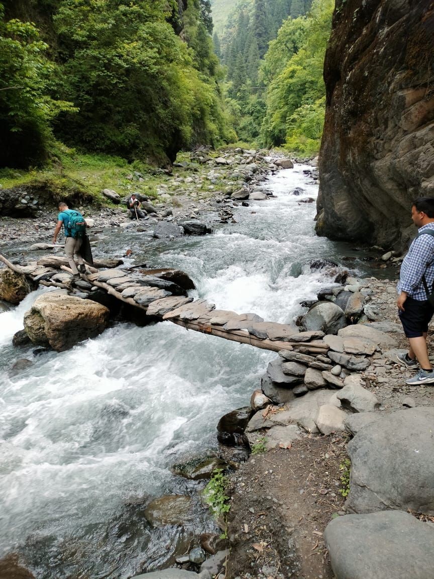 Mandi: Election officials carry election materials crossing a river as they leave for their respective polling stations ahead of last phase of Lok Sabha Election, in Mandi district, Thursday, May 30, 2024.(IANS)