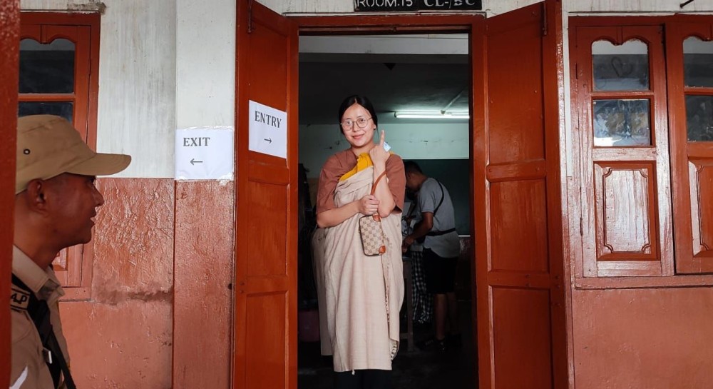 A mother carrying her infant showing her finger marked with the indelible mark after casting her vote in a ward in Kohima on June 26. (Morung Photo)