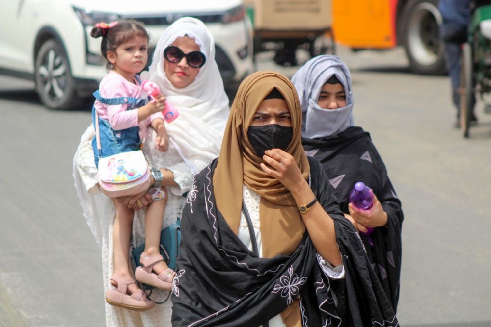 Meerut: Women walk past amid scorching heat on a hot summer day in Meerut on Thursday, June 6, 2024. (Photo: IANS)