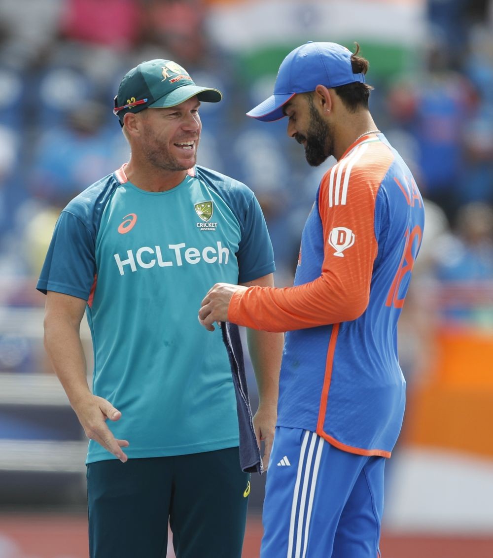 Saint Lucia : India's Virat Kohli with Australia's David Warner at the end of the ICC Men's T20 World Cup cricket match between India and Australia at Daren Sammy Cricket Ground in Saint Lucia on Monday, June 24, 2024. (Photo: IANS)