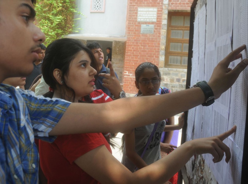 Parents and students check the 1st cut-off list of Delhi University for admissions to various undergraduate courses at North Campus in Delhi on June 27, 2013. (Photo: IANS)