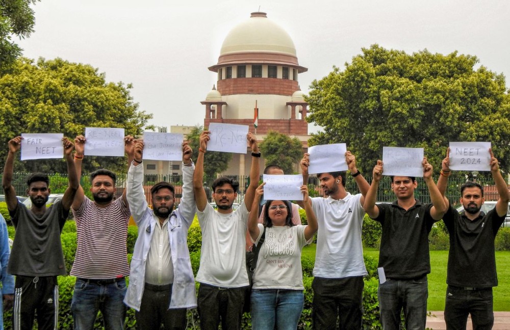 New Delhi: Students holding posters outside the Supreme Court during the hearing of the alleged NEET paper leak case in New Delhi on Thursday July 18,2024. (Photo: IANS/Anupam Gautam)