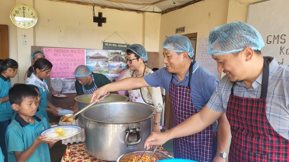 Kevileno Angami and others serves food to students as part of Tithi Bhojan at GMS Phezoucha on July 27.