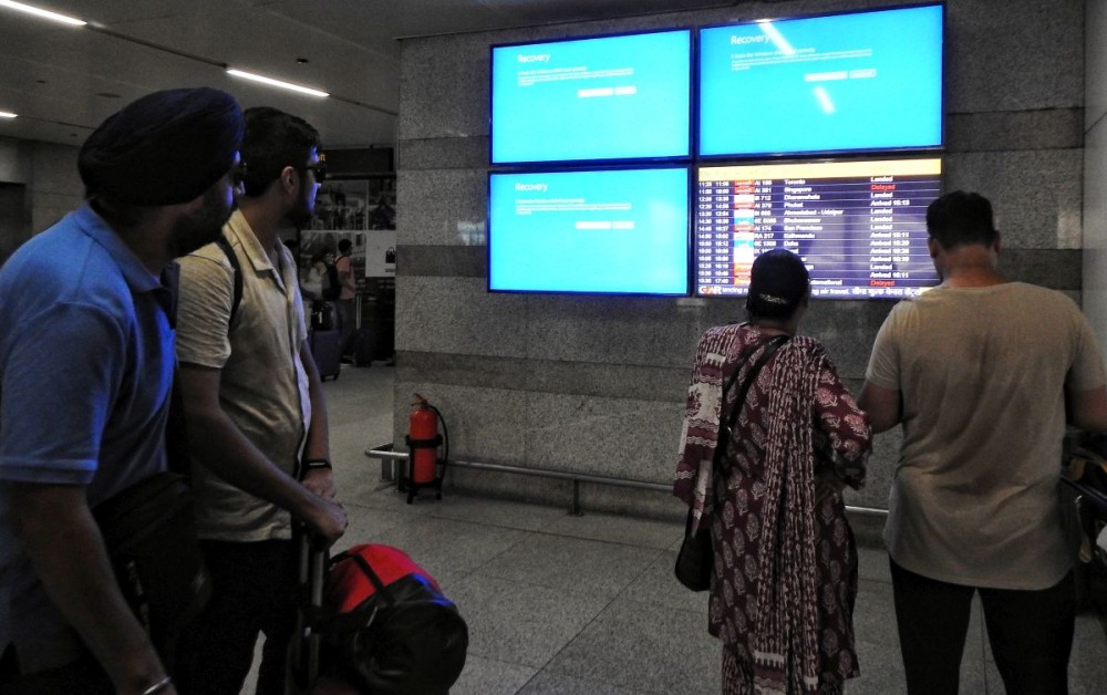 New Delhi: Passengers look at the displays as there are delays in airline services caused by an ongoing global outage of Microsoft at Terminal 3 of Delhi Airport in New Delhi on Friday, July 19, 2024. (Photo: IANS/Anupam Gautam)