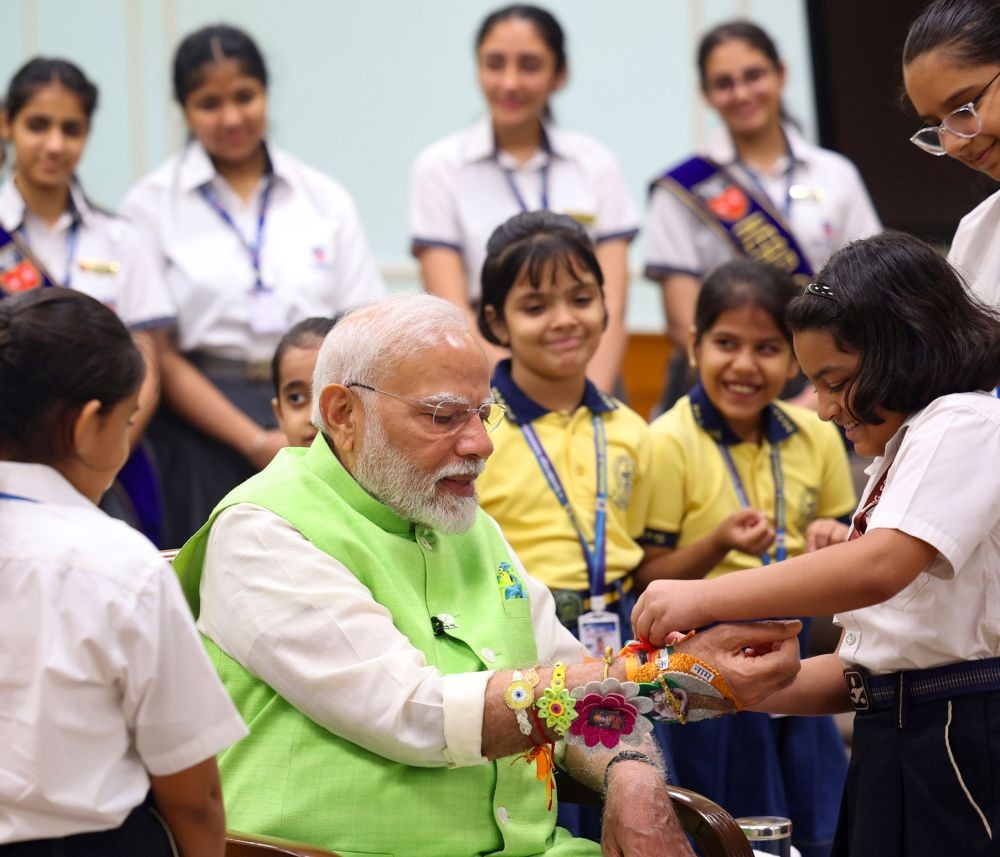 New Delhi: School student's ties ‘rakhi’ onto the wrist of Prime Minister Narendra Modi on the occasion of Raksha Bandhan in New Delhi on Monday, August 19, 2024. (Photo: IANS)
