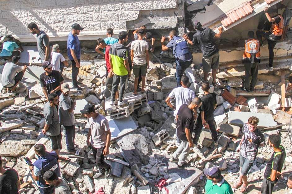 Gaza: People search for casualties at a school damaged by Israeli airstrikes in Gaza City, Aug. 4, 2024. At least 25 people were killed by Israeli airstrikes on the schools of al-Nasr and Hassan Salama in Gaza City, Palestinian security and medical sources said Sunday.(IANS/Xinhua)