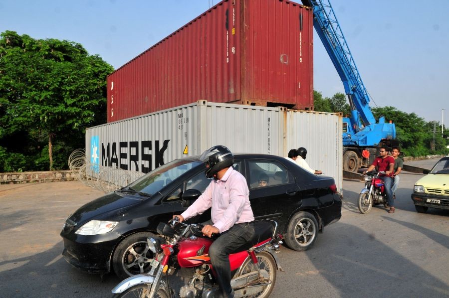 A road is blocked by a shipping container on a highway in Islamabad, capital of Pakistan, Aug. 14, 2014. A Pakistani cabinet minister said on Thursday that anti-government marchers will be allowed to enter the capital Islamabad and stage a sin-in. (Xinhua/Ahmad Kamal File Photo)