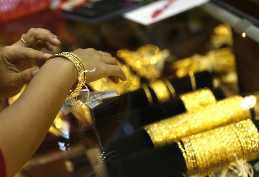 A customer chooses gold bracelets at a gold jewellery shop in Yangon, Myanmar, July 14, 2016. Local gold prices in Myanmar rose by about 85 U.S. dollars per tical (0.01633 kg) on Tuesday as compared with the prices before Brexit, according to local gold traders Wednesday. (Xinhua/U Aung)