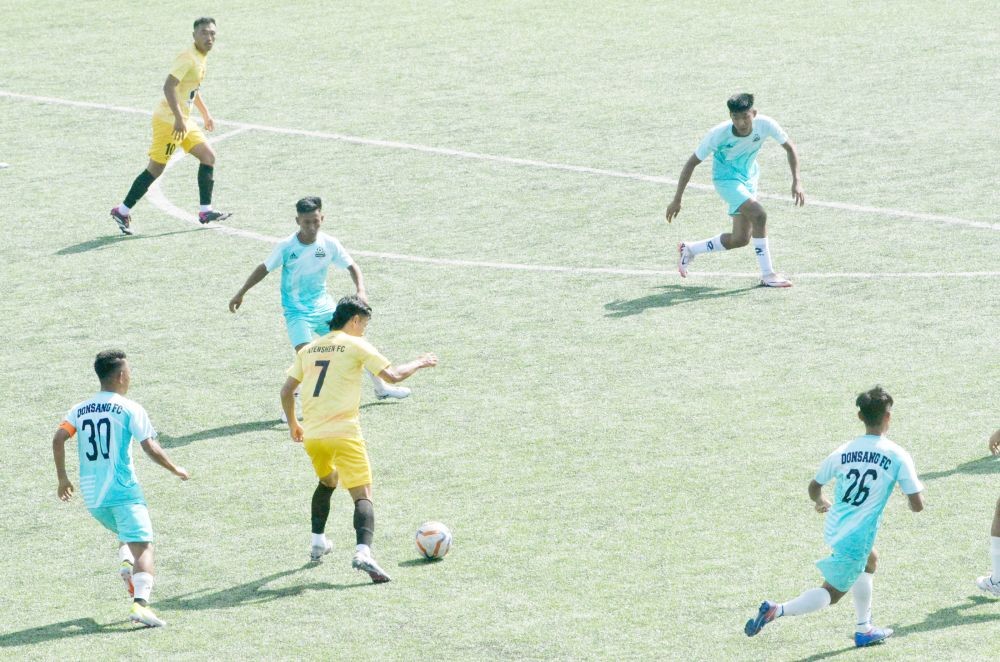 Nyenshen FC player in yellow jersey and Donsang FC players in blue jersey on October 22 at Loyem Memorial Astro Turf Ground in Tuensang town. (Morung Photo)