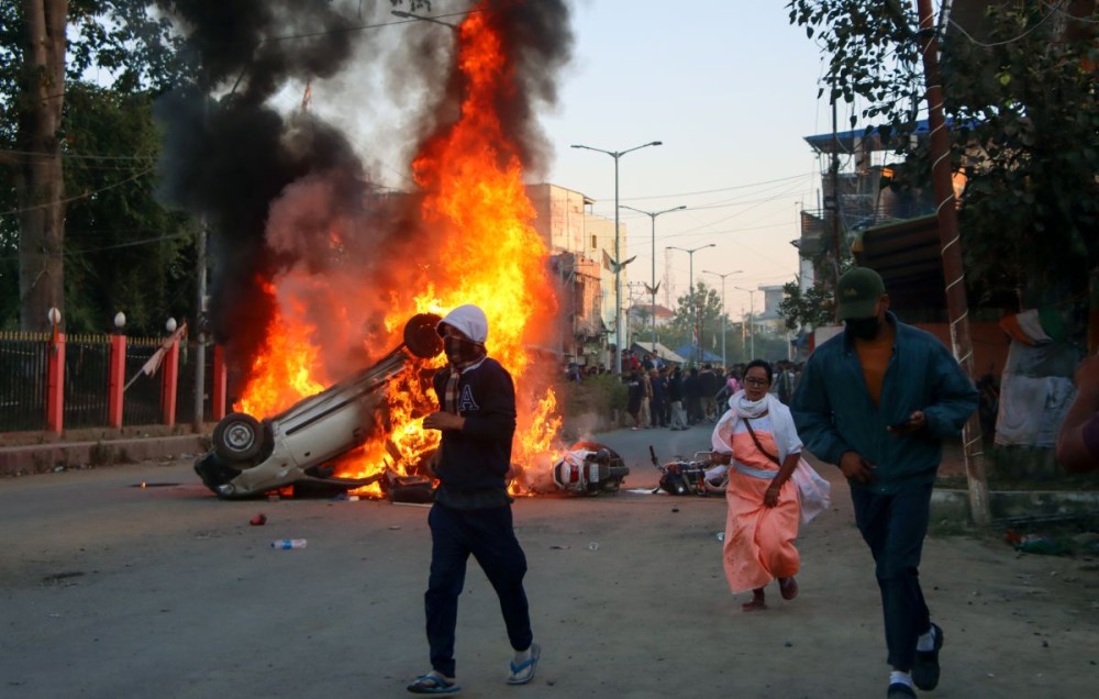 Jiribam: Smoke billows from a car set ablaze as protesters attacked the residence of Manipur Chief Minister N. Biren Singh, alongside homes of MLAs and ministers, engaging in vandalism and arson in Luwangshangbam on Sunday, November 17, 2024. (Photo: IANS)