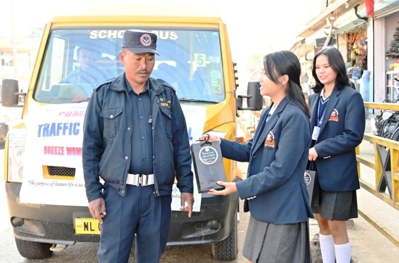 A student distributing a gift hamper to a traffic personnel as part of the LFI initiative.