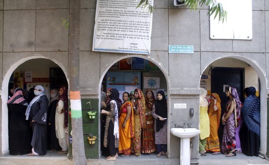 Voters stand in a queue to cast their vote in the sixth phase of the Lok Sabha elections at a polling station in New Delhi on Saturday, May 25, 2024. (Photo: IANS/Qamar Sibtain)