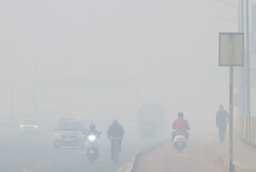New Delhi: Vehicles move cautiously through a thick layer of fog near Akshardham Temple, as reduced visibility marks a chilly winter morning in the capital in New Delhi on Thursday, December 19, 2024. (Photo: IANS/Wasim Sarvar)