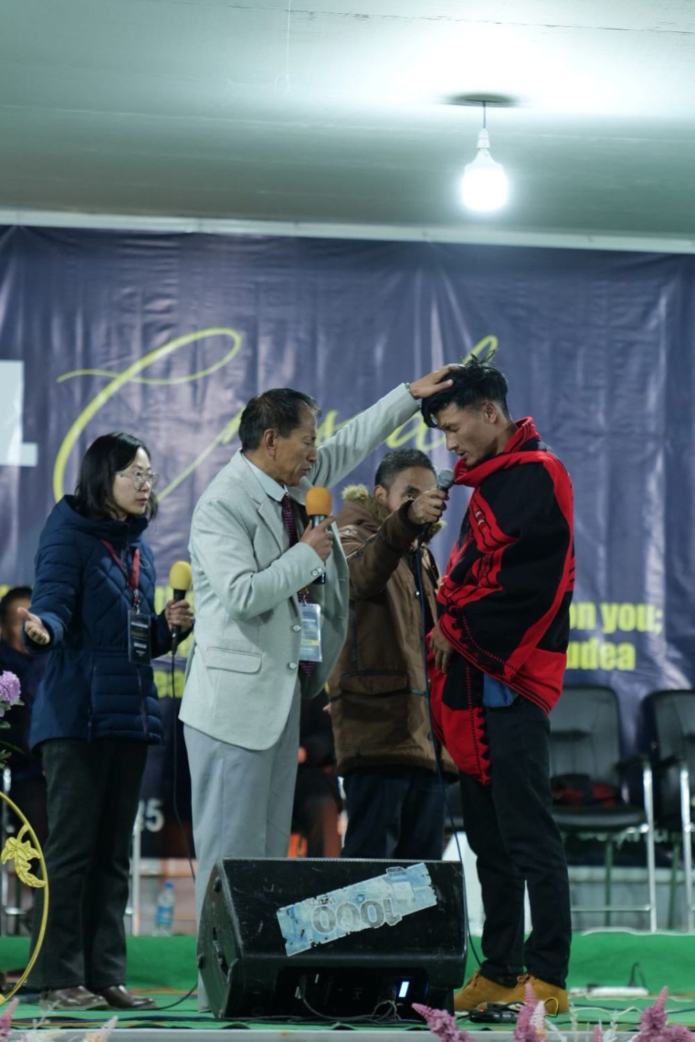 Rev Dr Zotuo Kiewhuo praying for a believer at Jakhama Inter-Denominational  Crusade.