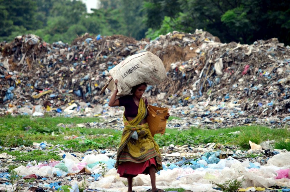 A woman returns after collecting waste plastics and other materials from a garbage dumping site in Dimapur. (Morung File Photo)