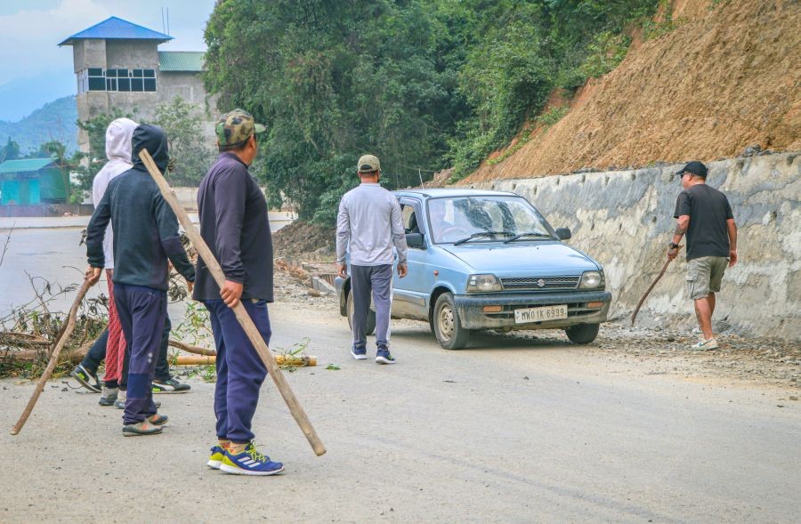 Strike supporters holding bamboo sticks stop passersby from entering the roads during the 48-hour statewide shutdown called by Coordinating Committee on Manipur Integrity (COCOMI), in Imphal, Thursday, May 22, 2025. (Photo: IANS/Ahanthem Bishwaorjit Meitei)