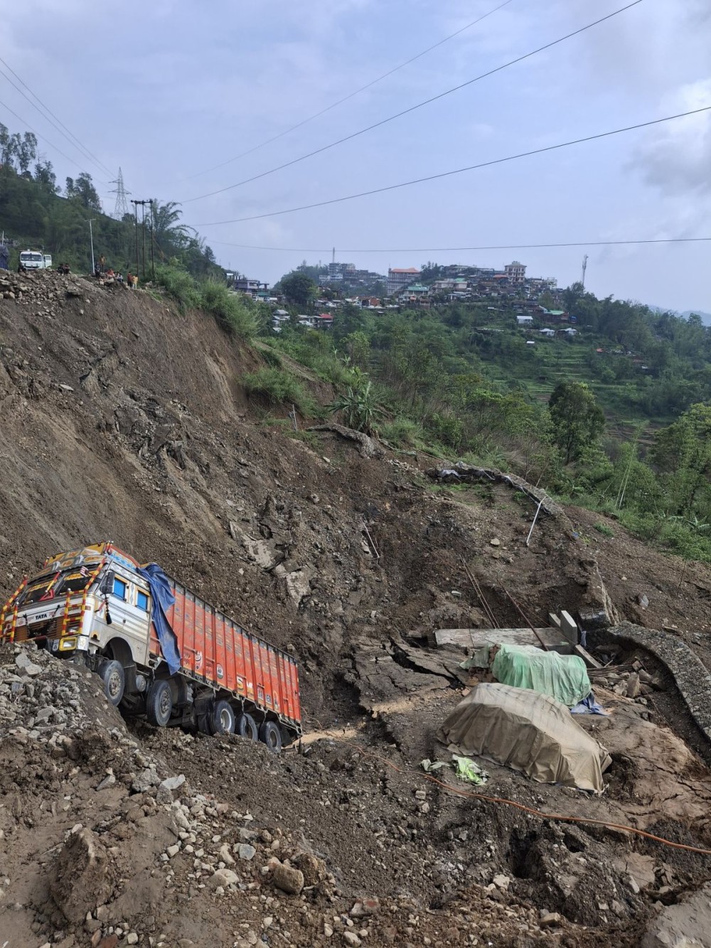 A Manipur-bound truck stuck at the site, along with the retaining wall, was swept away by a landslide at Phesama near Naga Heritage Village Kisama along National Highway-2 on June 2. Nagaland has been experiencing severe rain-related damage in recent days. (Morung Photo)