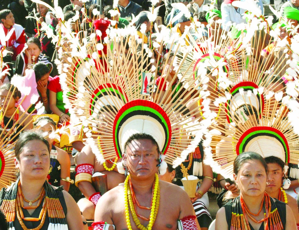 Naga men and women, in ceremonial dress, look on as they wait to perform during the first day of the annual celebration of Hornbill Festival at Kisama on Monday, December 1. (Caisii Mao)